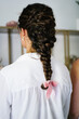 © Victor Gonzalez/ADDICTIVE STOCK - Back view of unrecognizable female with tender braid with ribbon standing in bright hairstyle salon