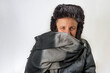 © Marco Taliani - Middle-aged white man completely covered in jacket, woolen scarf and fur hat, shelters himself from the cold and wind