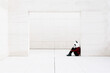 © VISTA by Westend61 - Depressed woman wearing panda mask sitting at doorway against white wall