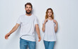 © SHOTPRIME STUDIO - A guy and a beautiful woman in the same clothes on a light background are gesticulating with their hands