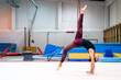 © David Prado/Stocksy - young artistic gymnast woman performing and training somersaults