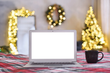 Wall Mural - Laptop with blank screen in a cozy Christmas interior