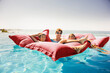 © Sollina Images/Blend Images - Grandmother and grandchildren relaxing on pool raft
