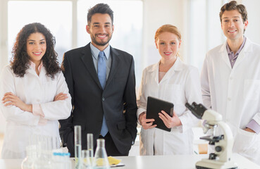 Scientists and businessman smiling in laboratory