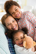 © JGI/Jamie Grill/Blend Images - Black mother and children smiling on sofa