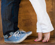 © JGI/Jamie Grill/Blend Images - Woman standing on tiptoes to kiss boyfriend