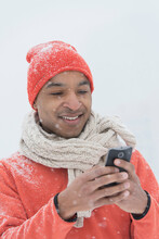 Black Man Using Cell Phone In Snow