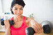 © JGI/Jamie Grill/Blend Images - Mixed race woman lifting weights in gym