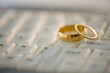 © JGI/Jamie Grill/Blend Images - Close up of wedding rings on computer keyboard