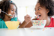 © JGI/Jamie Grill/Blend Images - Mixed race sisters eating cereal