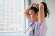 © JGI/Jamie Grill/Blend Images - Nurse tying her hair up in hospital