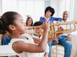 © JGI/Jamie Grill/Blend Images - African American family watching daughter play trumpet