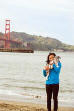 Chinese Girl Holding Dog On Beach