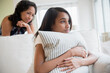 © JGI/Jamie Grill/Blend Images - Mother watching pensive daughter clutching pillow