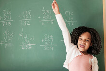 African American Student Cheering Near Chalkboard In Classroom