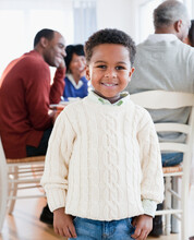 African American Boy Smiling With Family In Background
