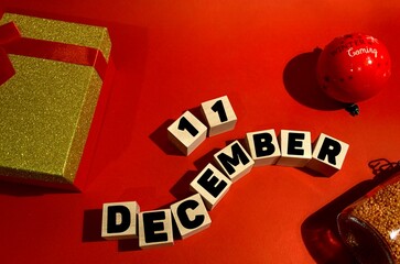 December 11 on wooden cubes .Gift box on a red background.The first month of winter.Calendar for December.New Year