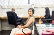© Adam Hester/Blend Images - Portrait of smiling Asian woman sitting in office