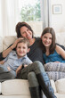 © Tetra Images/Tetra Images - Mother and kids(8-9, 10-11) sitting on sofa