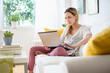© Tetra Images/Tetra Images - Woman with laptop sitting on sofa