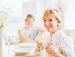 © Daniel Grill/Tetra Images - Mother drinking wine during dinner, out-of-focus daughter in background