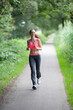 © Mark de Leeuw/Tetra Images - Young woman jogging in park