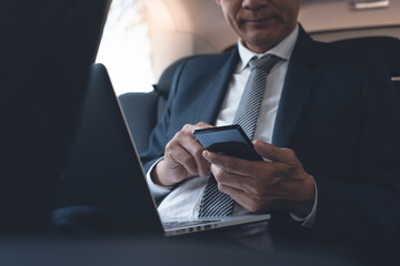 Poster - Businessman using mobile phone and working on laptop computer inside a car