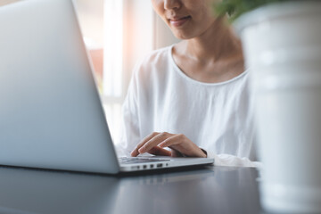 Wall Mural - Asian business woman working on laptop from home office