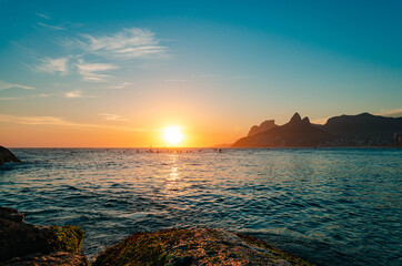 Sunset in rio de janeiro with gavea stone and the two brothers' hill in the background.