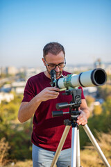 Wall Mural - amateur astronomer looking at the sky with a telescope.