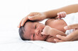© amorn - African American newborn baby or infant lying on white bed while mother’s hands takes care and comforting. Family, love and new life concept