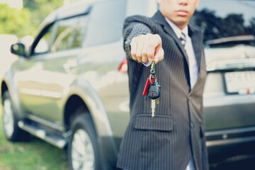 close up of businessman or salesman giving car key,concept of transportation with automobile second hand sale 