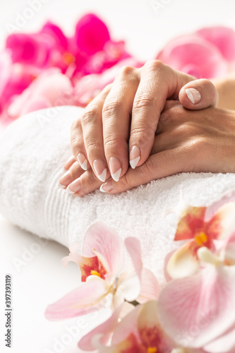 Soft hands skin after a lotion placed on a towel surrounded by flowers Canvas