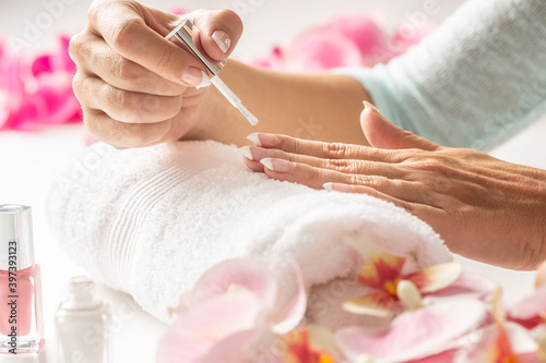 Foto Getting manicure done by a woman applying nail polish cosmetics