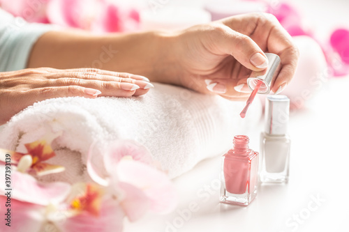 Fényképezés Light pink nail polish applied on a hand of a woman