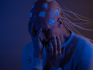 Wall Mural - man with a bald head with wires connected. Fear and anxiety. Examination of the brain,