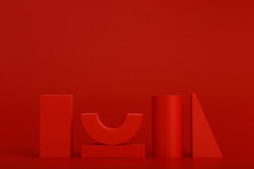 Wall Mural - Monochromatic geometric still life with red figures on red background and space for text