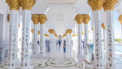 Wall Mural - Sheikh Zayed Grand Mosque timelapse in Abu Dhabi, the capital city of United Arab Emirates. People walking between columns. Blue sky at sunny day