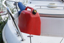Big Red Can With Gasoline Fuel On White Bowrider Motor Boat Bow Deck With Railing, Reserve Watercraft Refueling