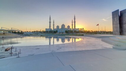 Wall Mural - Sheikh Zayed Grand Mosque in Abu Dhabi at sunset timelapse, UAE. Evening view from Wahat Al Karama with reflections on water