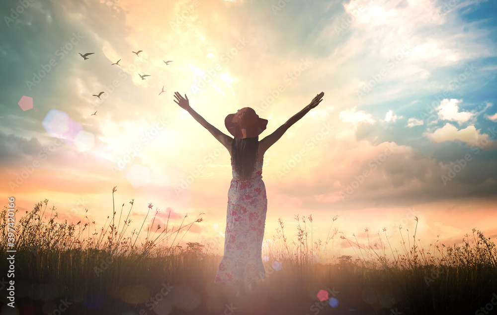 International women's day concept: Silhouette of healthy woman raised hands for praise and worship God at autumn sunset meadow background - obrazy, fototapety, plakaty 
