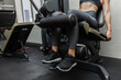 © splitov27 - Leg workout. Young athletic woman doing leg extension in exercise machine at gym.