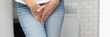 Female hands between legs in jeans close-up. Diagnosis and treatment of sexually transmitted diseases concept.