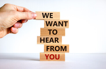Wall Mural - Support symbol. Wooden blocks with words 'we want to hear from you'. Male hand. Beautiful white background. Copy space. Business and support concept.