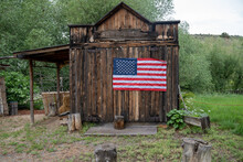 Old Abandoned Shed With An American Flag, In The Ghost Town Of Virginia City, Montana