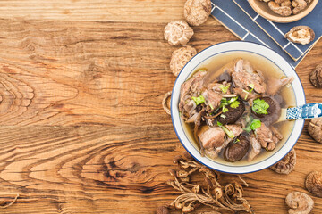 Wall Mural - A bowl of mushroom lao duck soup on a cutting board