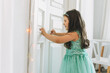 © Galina Zhigalova - Cute happy little girl in mint fancy dress open door at the bright room, birthday, christmas time