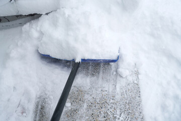 Wall Mural - close up on snow shovel removing snow on the driveway