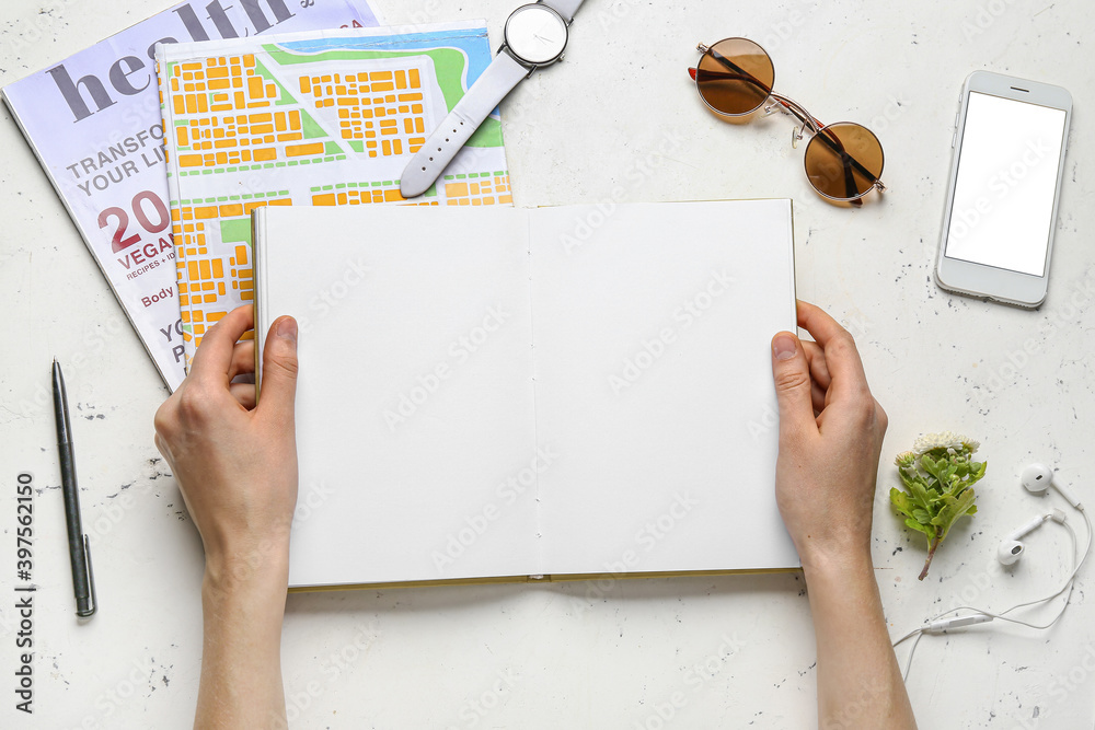 Woman with blank book at table, top view