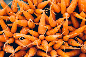 Heap of fresh carrots displayed in a farmer's market. Healthy, fresh and organic fruit and vegetable.